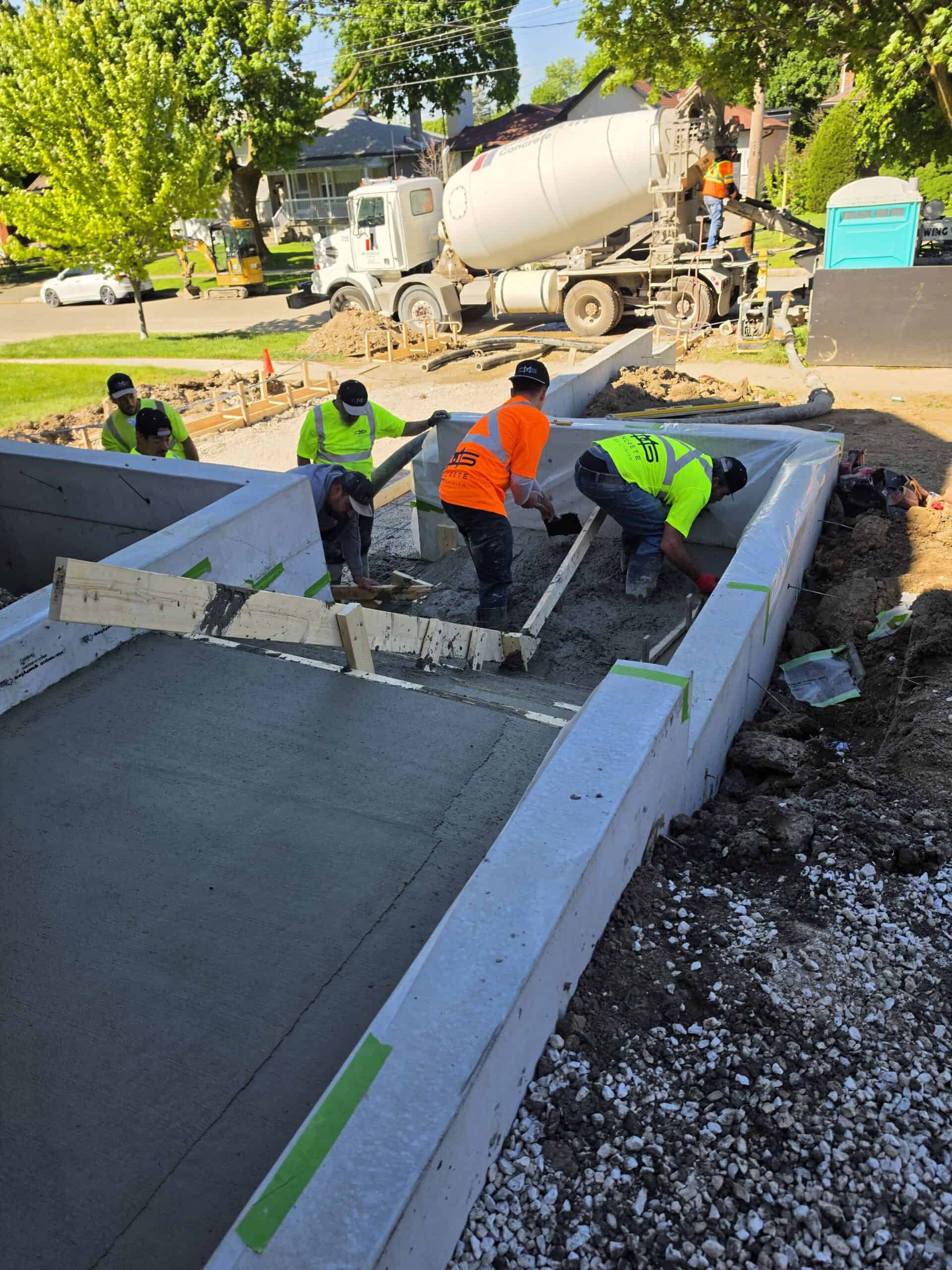 Crew placing and finishing concrete for a slab using a line pump.