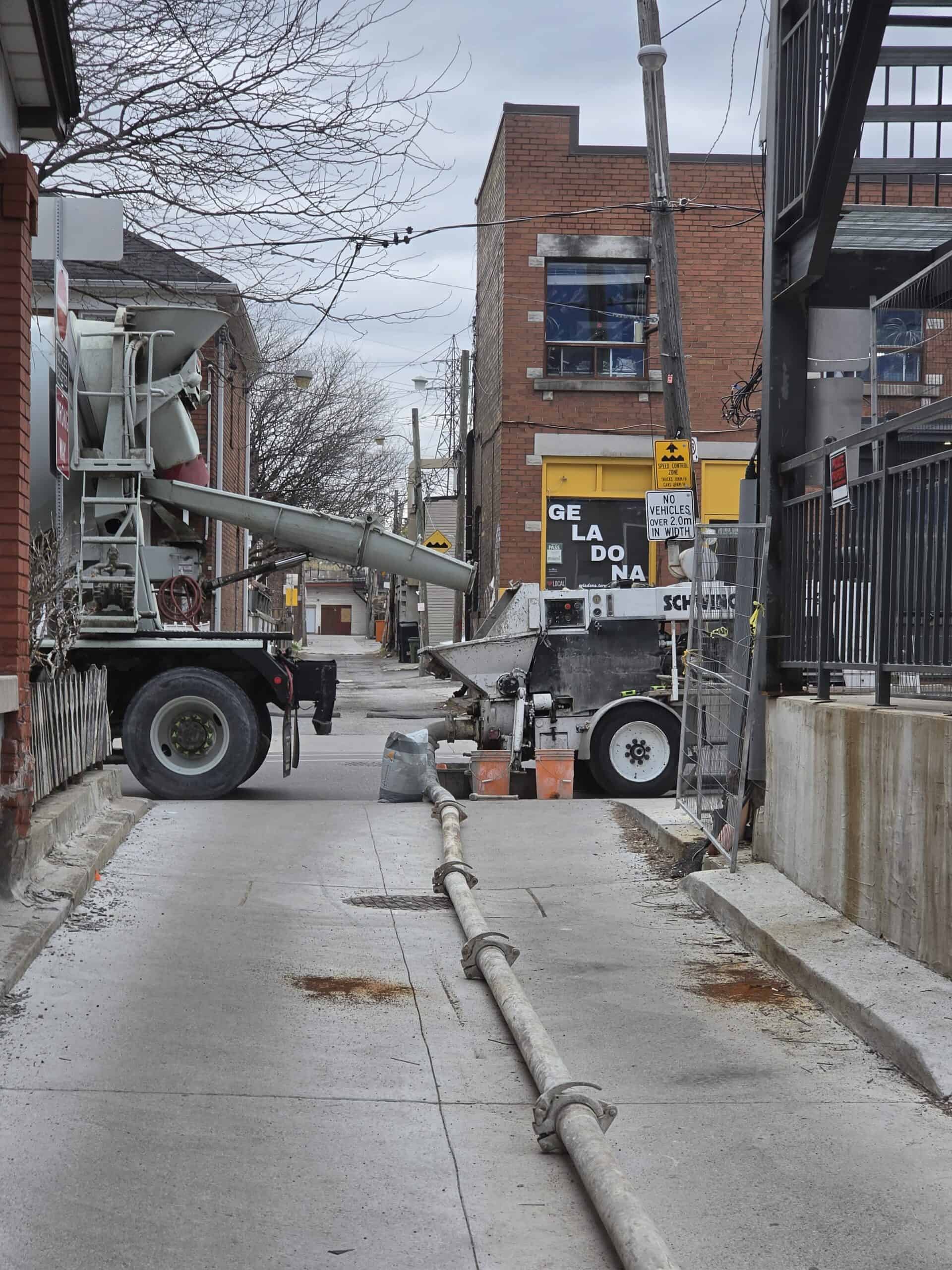 Concrete line pump connected to a ready-mix truck at a Toronto residential job site.