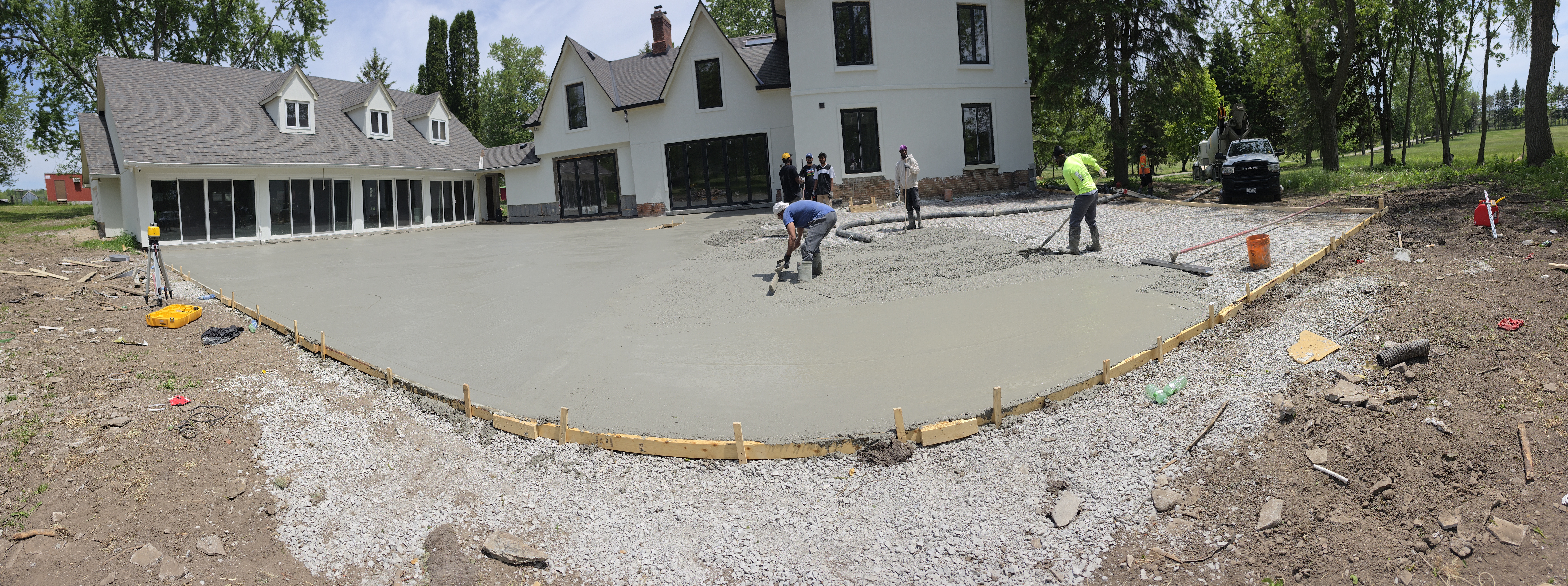 Fresh residential concrete slab being finished in front of a home.